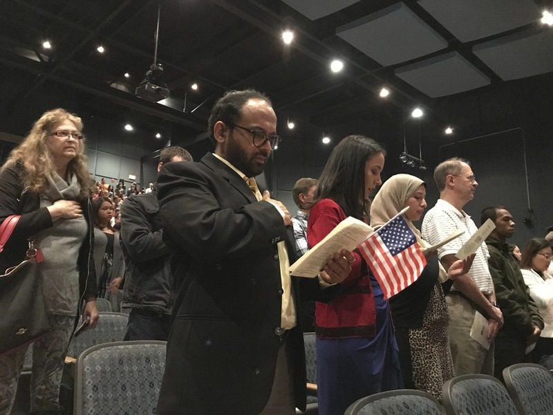 New citizens reciting the Pledge of Allegiance at the USCIS naturalization ceremony, Windham High School, October 2019